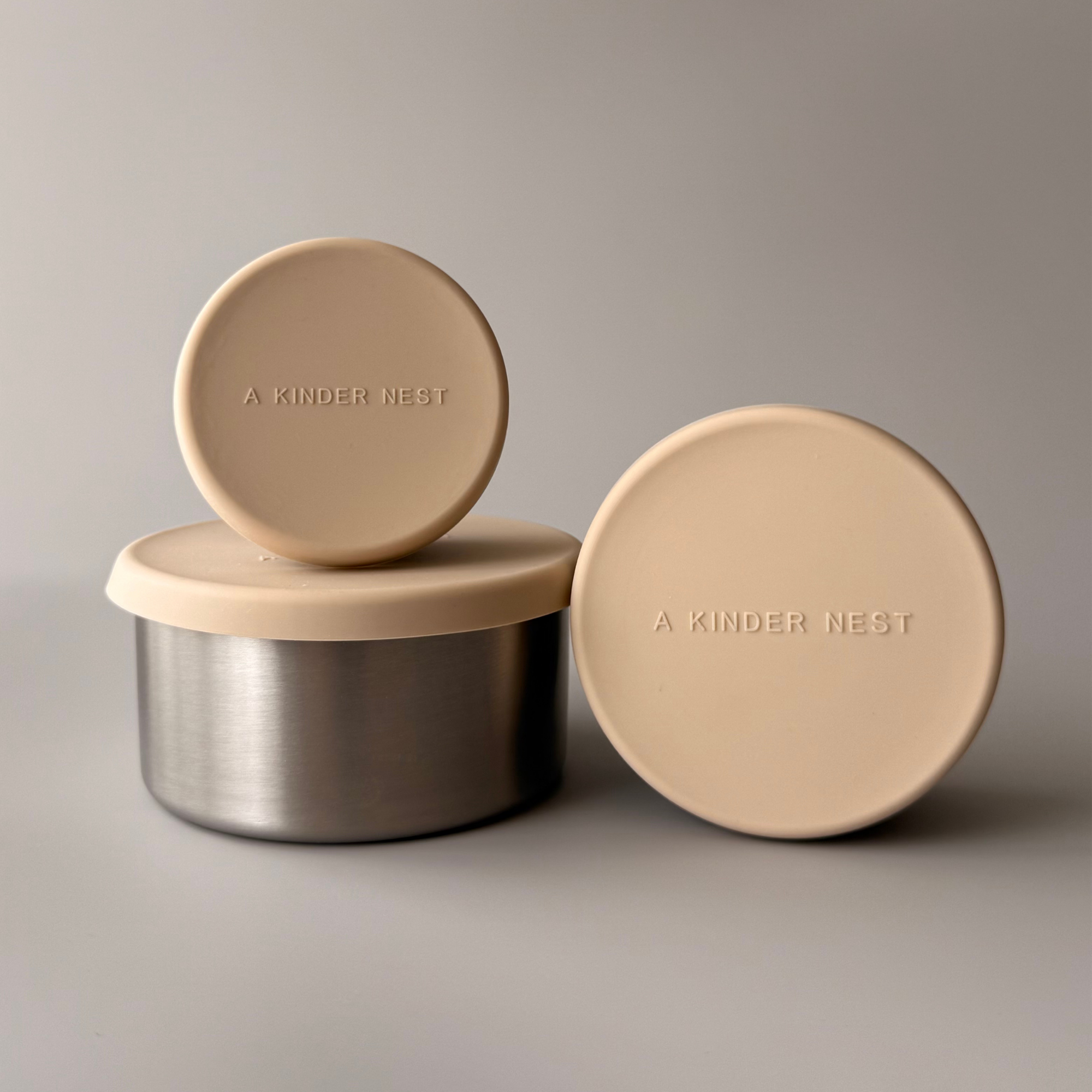A Kinder Nest set of 3 nesting stainless steel food storage containers with leakproof LFGB silicone lids for plastic-free snacks.