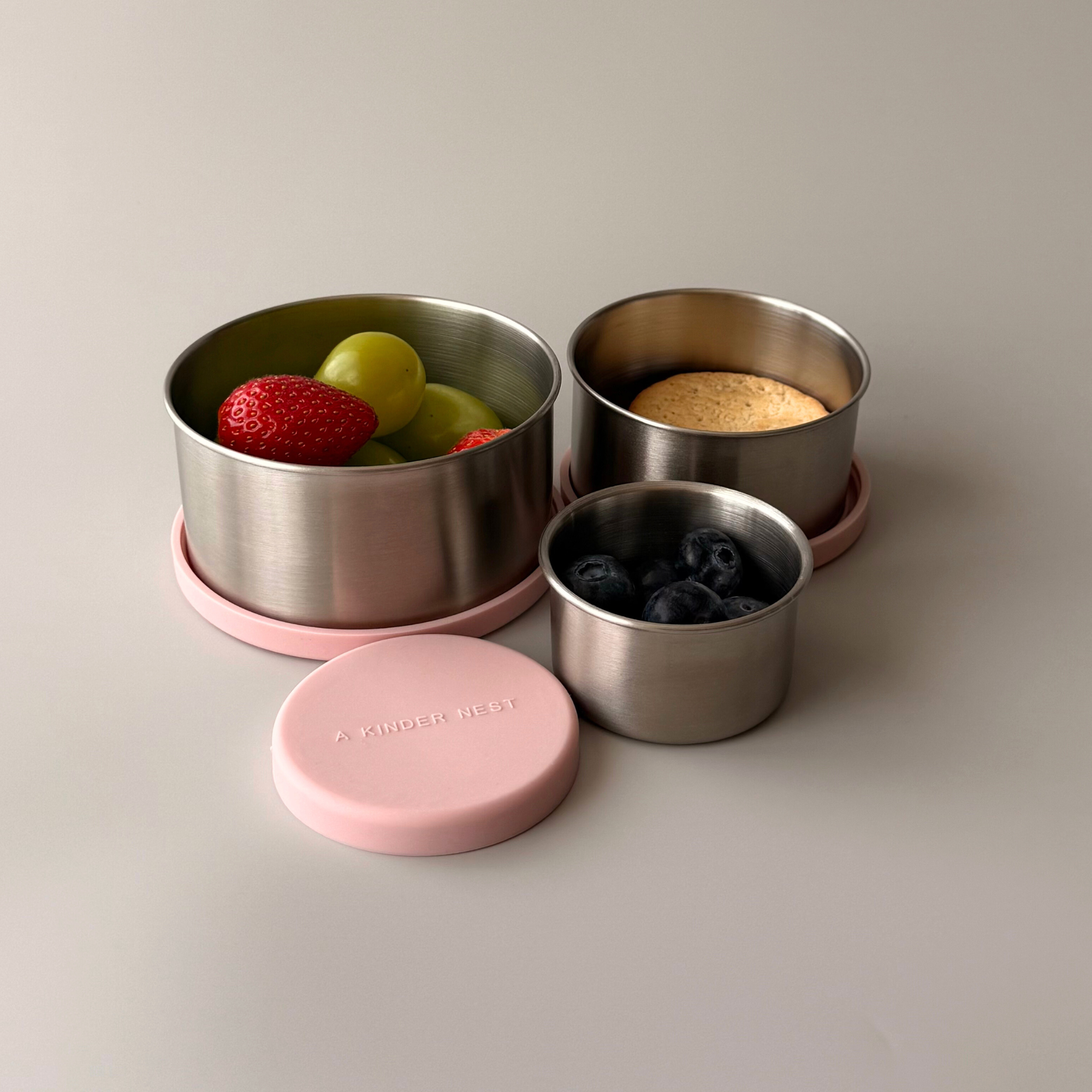 Space-saving nesting design showing three different sizes of stainless steel containers stacked together.