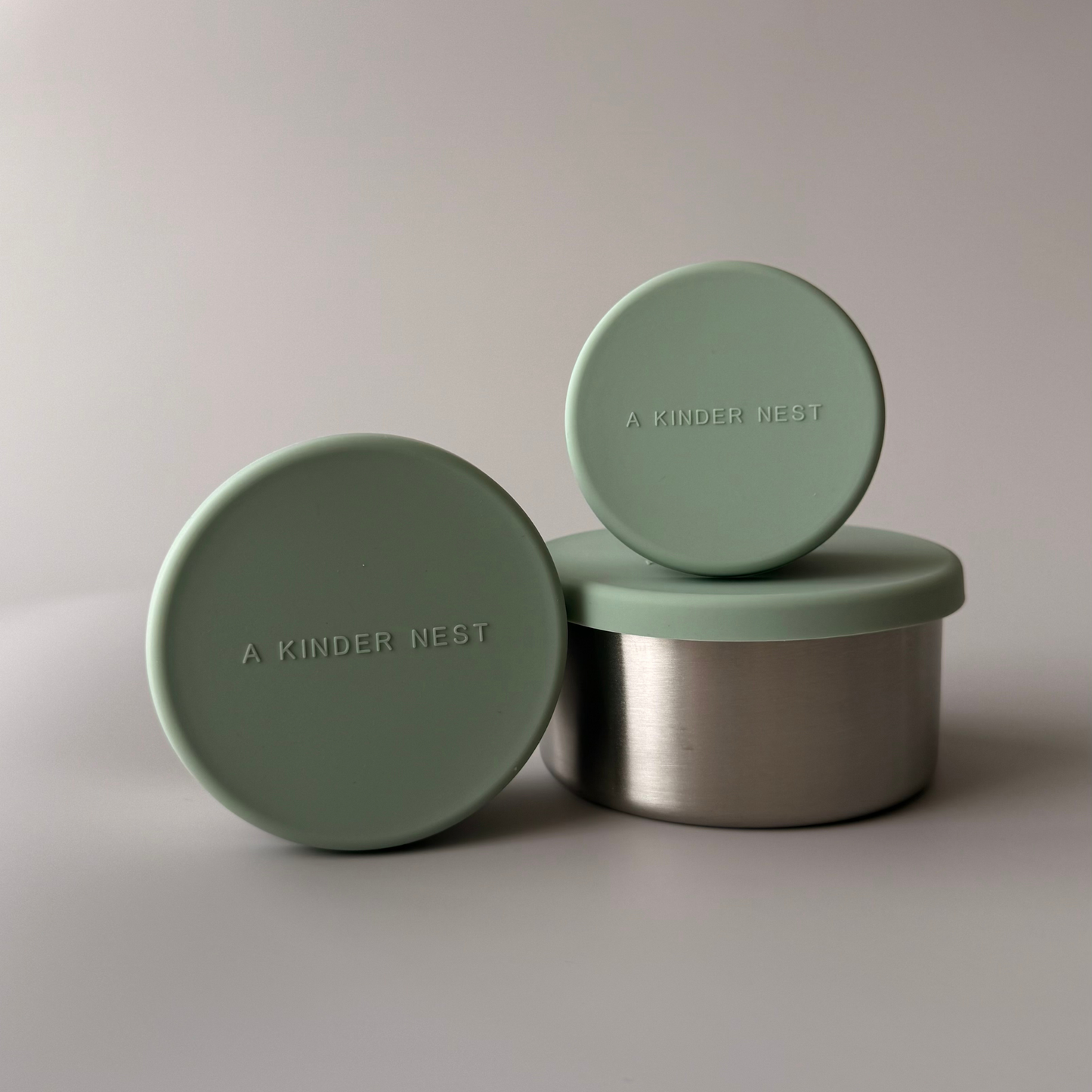 Stackable set of three stainless steel containers with sage leak proof silicon lids. A Kinder Nest.
