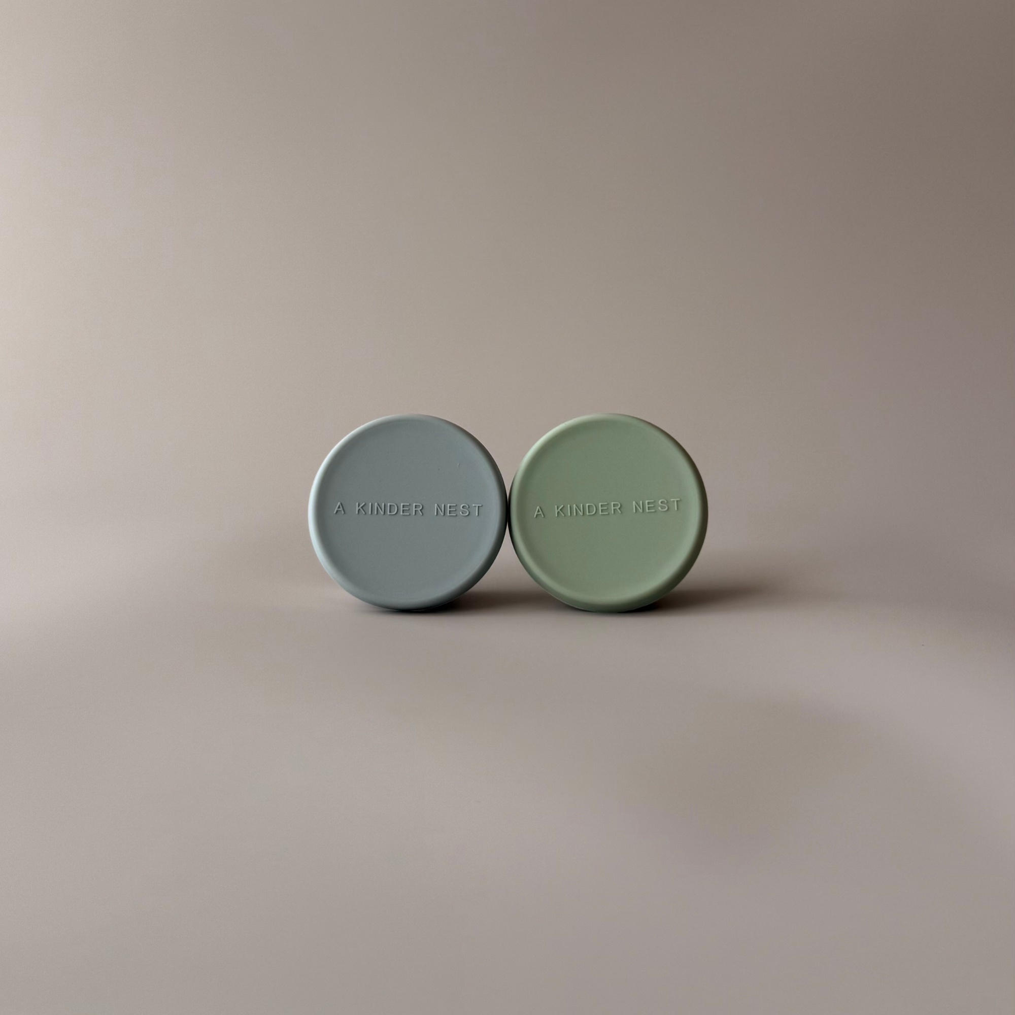 Pair of small metal condiment pots with colorful LFGB-certified silicone lids for plastic-free snacks.