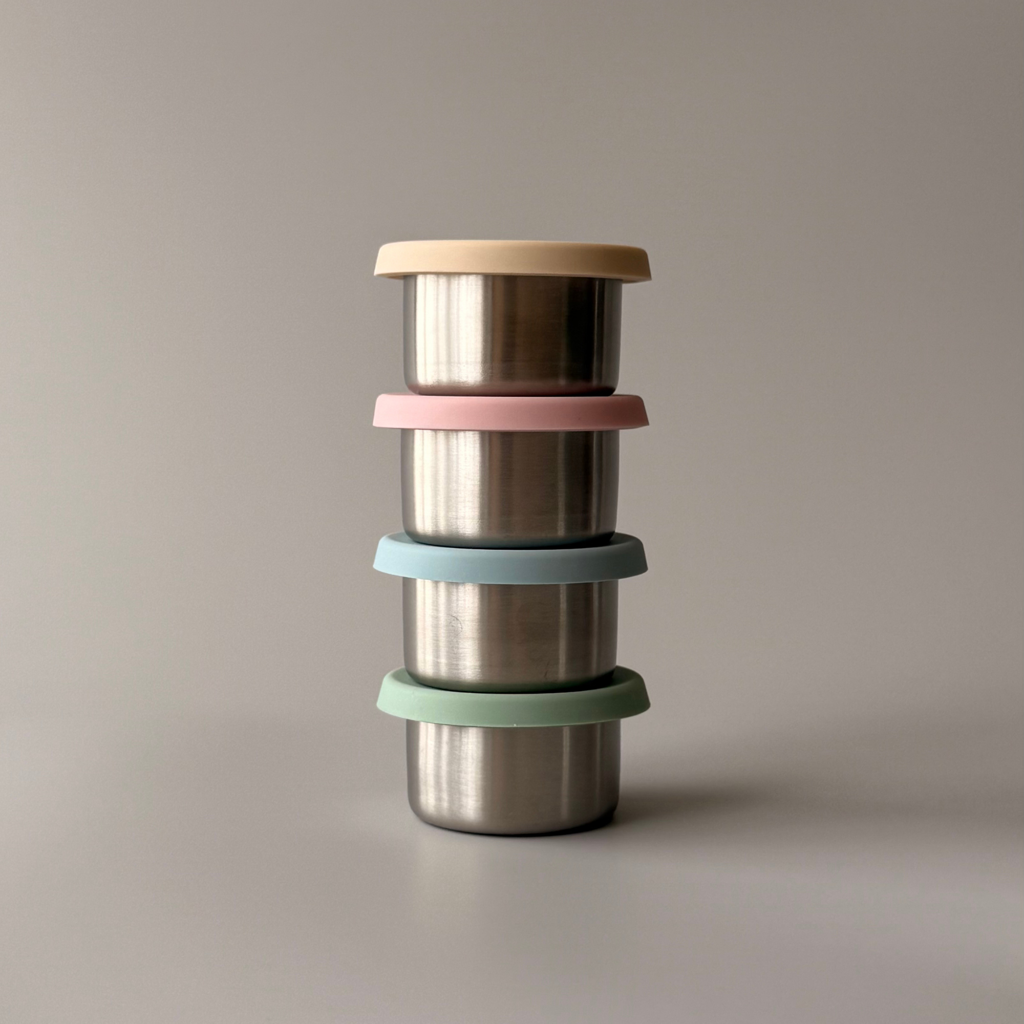 A Kinder Nest set of 2 stainless steel mini sauce containers with leakproof silicone lids, 60ml capacity.