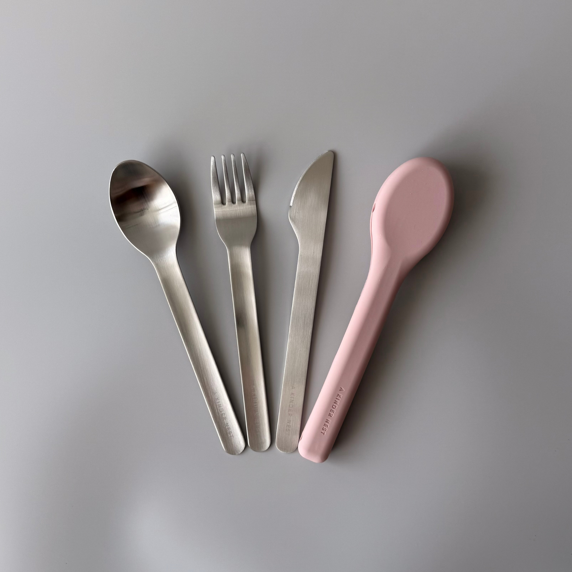 A Kinder Nest 3-piece reusable stainless steel cutlery set with a washable silicone travel pouch.